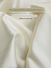 A close-up view of off-white, ribbed fabric with a subtle sheen and visible texture.