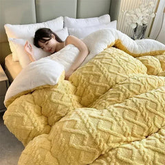 A woman sleeps under a thick, yellow, textured faux-lambswool comforter on a bed.