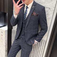 A man wearing a slim-fit navy blue plaid three-piece suit with a matching vest and trousers.