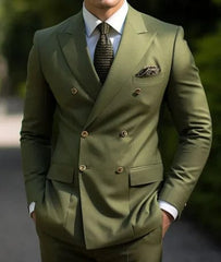 A man wears a slim-fit olive green double-breasted suit with a peaked lapel and a patterned tie.