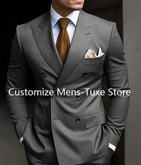 A man wears a grey double-breasted suit with a peaked lapel, white shirt, and brown tie.