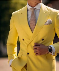 A man wears a bright yellow double-breasted suit jacket with a white shirt and textured tie.