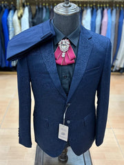 A navy blue floral jacquard men's suit jacket with a black shirt and a maroon bow tie.