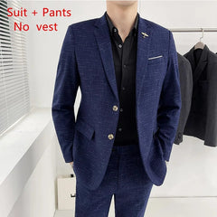A man wears a blue textured two-piece suit with a black button-down shirt.