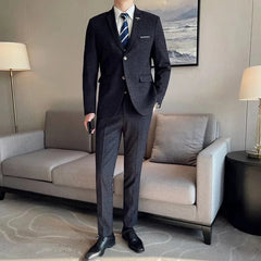 A man wearing a dark grey patterned three-piece suit with a white shirt and striped tie.
