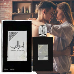 A bottle of Ameer Al Arab perfume and its box are displayed next to a couple embracing.