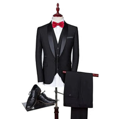 A black three-piece suit with a shawl collar, white shirt, red bow tie, and black dress shoes.