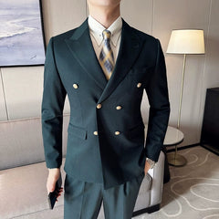 A man wears a dark green double-breasted slim fit suit with gold buttons and a plaid tie.