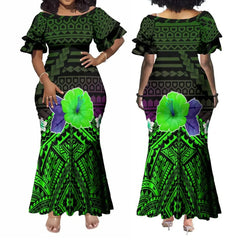 A woman wears an ankle-length, off-the-shoulder dress featuring a green Polynesian tribal print.