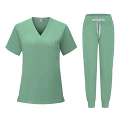 A sage green women's scrub set featuring a V-neck top and jogger-style pants with a drawstring.