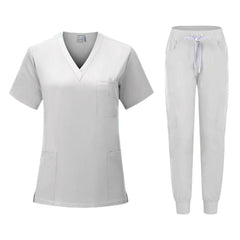 A light gray women's scrub set featuring a V-neck top with pockets and matching jogger pants.
