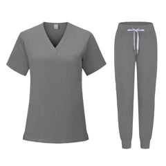 A grey women's scrub set featuring a V-neck top with pockets and matching jogger-style pants.