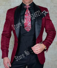 A burgundy patterned suit jacket with a black shawl lapel worn with a black vest and paisley tie.