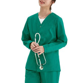 A person wears a long-sleeved, V-neck green medical scrub top while holding a stethoscope.