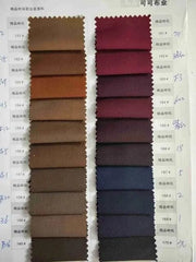 A fabric swatch card displaying various shades of brown and red textile samples for suits.