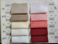 A fabric swatch book displaying a variety of suit material colors ranging from neutrals to reds.