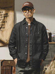 A man wears a thick, long-sleeved, black striped button-down shirt with a point collar.