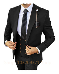 A man wears a black three-piece suit with a white shirt, polka dot tie, and a lapel chain.