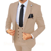 A man wearing a three-piece khaki suit with a white shirt and a black polka dot tie.