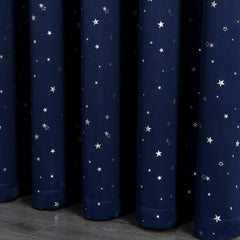 Navy blue blackout curtains featuring a silver star pattern with a grommet top.