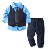 A formal boys' suit set featuring a light blue button-down shirt, navy vest, tie, and trousers.