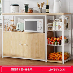 A light wood kitchen sideboard with a white metal frame, microwave shelf, and wire storage baskets.