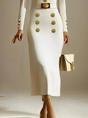 A woman wears a long-sleeved white midi dress featuring gold buttons and a matching belt.