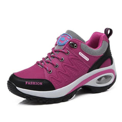 A magenta lace-up sneaker with a black trim, white platform sole, and visible air cushioning.