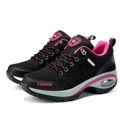 Black and pink lace-up platform sneakers with a cushioned sole and breathable mesh details.