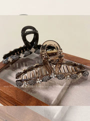 Two large hair claw clips decorated with sparkling rhinestones and flower-shaped accents.