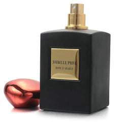 A black rectangular perfume bottle with a gold label reading Joybelle Prive Rose D'Arable.