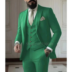 A man wears a slim-fit, three-piece emerald green suit with a white shirt and a light tie.