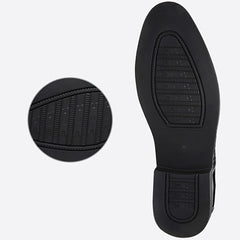 The black rubber outsole of a pointed-toe men's dress shoe is shown with a zoomed-in detail view.