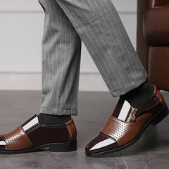 A pair of brown and dark brown pointed-toe dress loafers featuring a side zipper and perforated detailing.