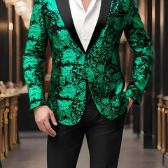 A man wears a green and black paisley patterned blazer with a black lapel and white shirt.