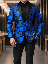 A man wears a blue and black paisley patterned blazer with a black lapel and one button closure.
