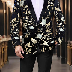 A man wears a black single-breasted blazer featuring a gold and light blue floral bird pattern.