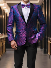 A man wears a vibrant purple and blue floral paisley tuxedo blazer with a matching bow tie.