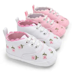 Two pairs of baby girl canvas crib sneakers with floral prints and scalloped trim.