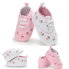 Baby girl canvas crib sneakers featuring a floral print and soft soles in pink and white.