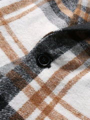 A close-up view of a men's plaid blazer featuring a black button on a brushed fabric texture.