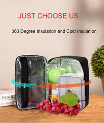 A black insulated lunch bag is open on a wooden table, containing a food container and fruit.