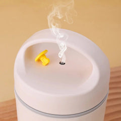 A white, round, thermal stainless steel lunch box with a small yellow vent releasing steam.