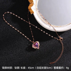 A rose gold stainless steel necklace featuring a heart-shaped pendant with a colorful crystal.