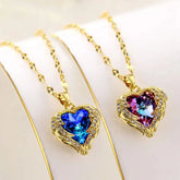 Two gold-tone heart-shaped pendant necklaces with colorful crystals and angel wing accents.