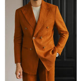 A man wears a brown double-breasted linen suit with a slim fit and a white shirt underneath.