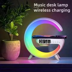 A G-shaped desk lamp with a digital clock and a smartphone resting on its wireless charging base.
