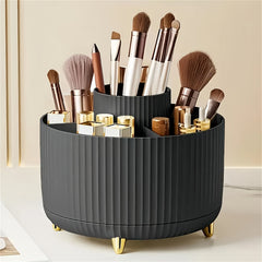 A black, ribbed, rotating makeup organizer with gold feet, filled with brushes and cosmetics.