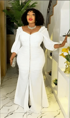 A woman wears a white, long-sleeved, floor-length maxi dress with a front slit and ruched bodice.