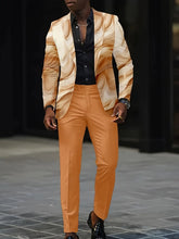 A man wears a tan and cream abstract print blazer with solid orange trousers and a black shirt.